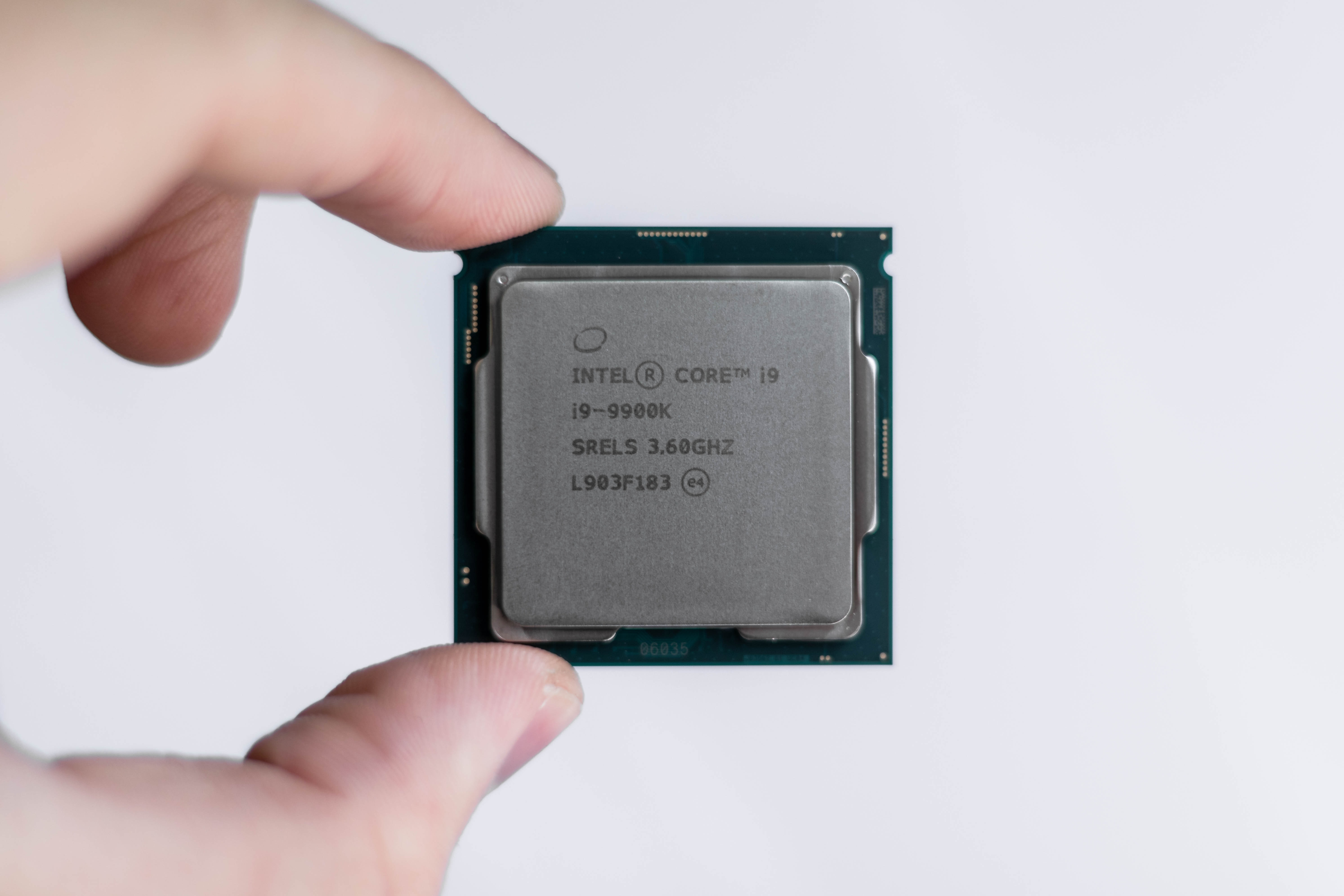 Someone holding a CPU chip by their thumb and index finger